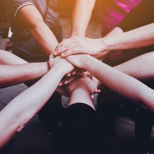 a group of hands coming together for teamwork