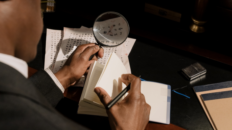 A detective looking through a magnifying glass at some documents.