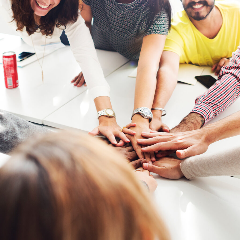 a group of adults putting hands in